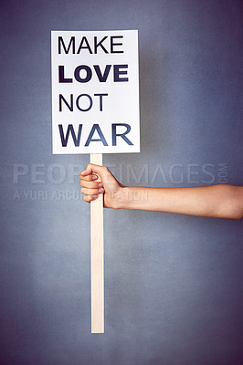 Buy stock photo Shot of an unidentifiable young woman holding up a poster with a message on it in studio