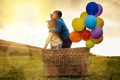 Buy stock photo Shot of a pair of adorable siblings playing with a basket and a bunch of balloons outside