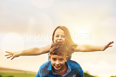 Buy stock photo Portrait of an adorable little boy giving his little sister a piggyback ride outside