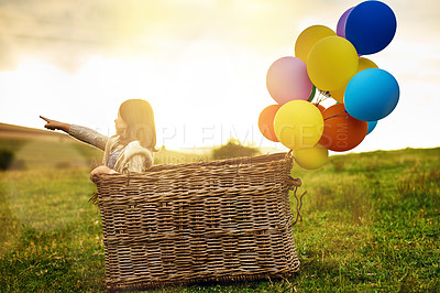 Buy stock photo Balloon, basket and girl with adventure in field for imagination, creativity or explore on holiday. Nature, kid and invention with point at sunset for fantasy travel direction, location and childhood