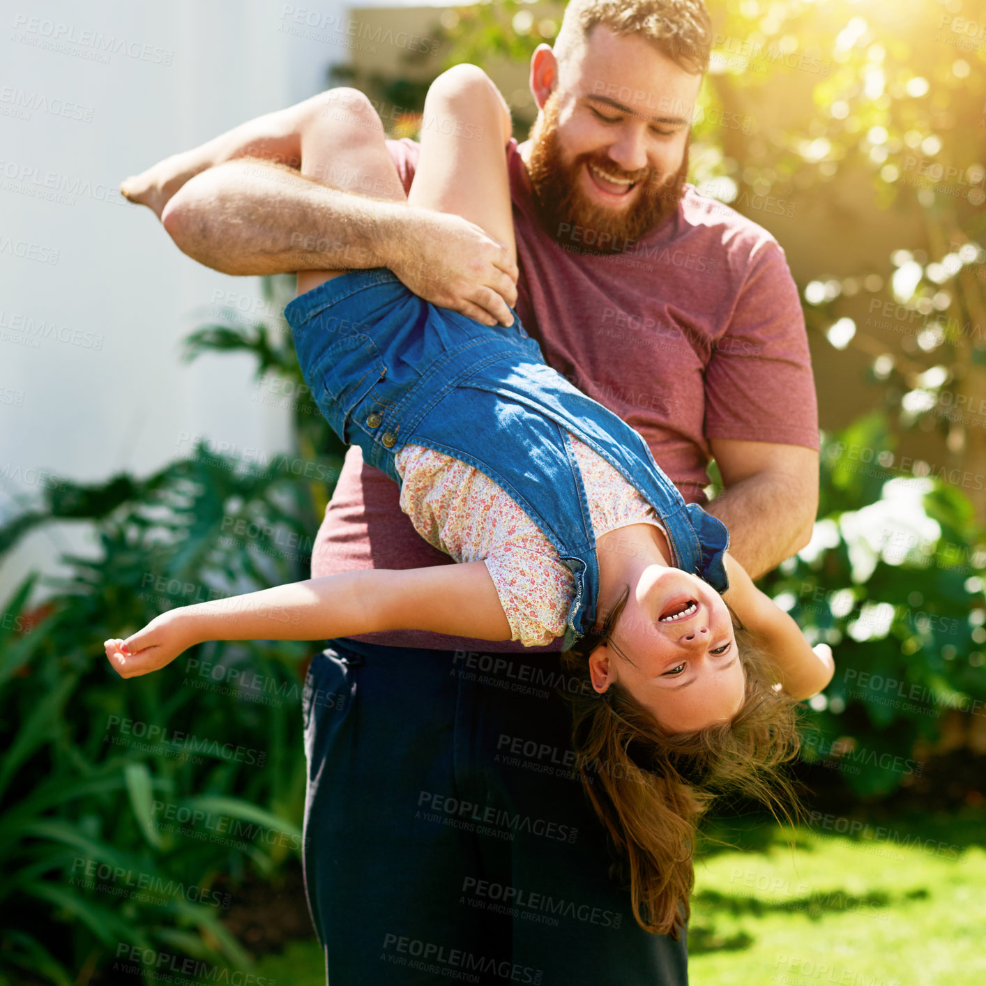 Buy stock photo Shot of an adorable little girl having fun with her father in their backyard