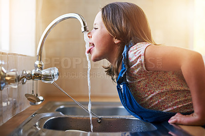 Buy stock photo Drinking water, tap and child with tongue out in a home kitchen with a smile. House, kids and youth feeling thirsty, cheeky and curious at a sink trying to drink from faucet for hydration alone