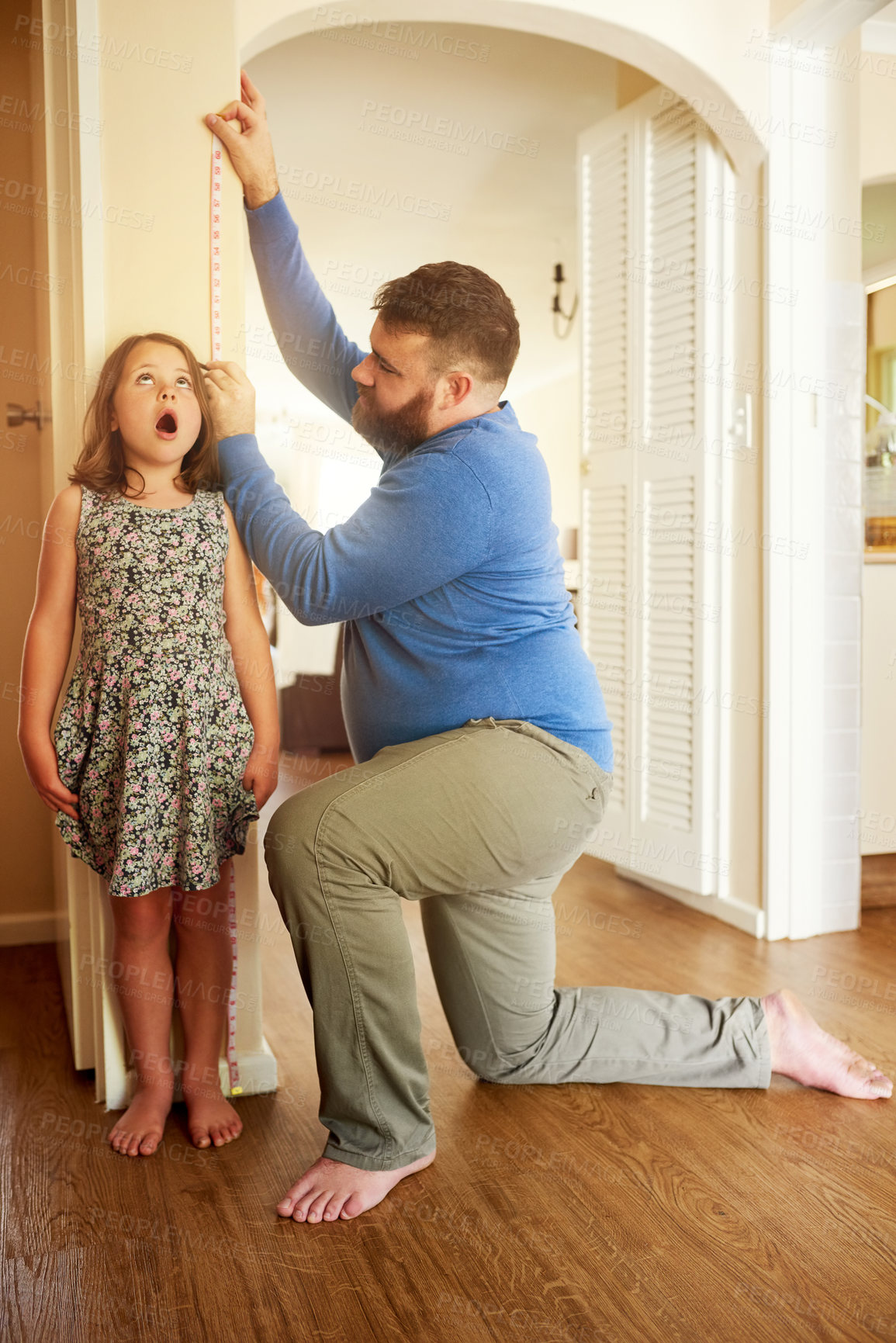 Buy stock photo Father, daughter and measure on wall in home for growth, healthy development and surprised by height increase. People, dad and girl with tape for growing progress, childhood memories and parenting