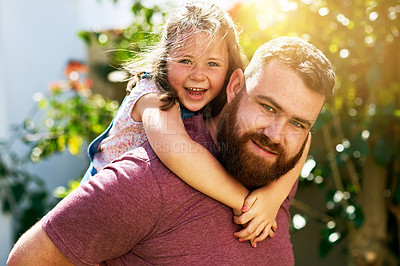 Buy stock photo Shot of an adorable little girl enjoying a piggyback ride from her father in their backyard
