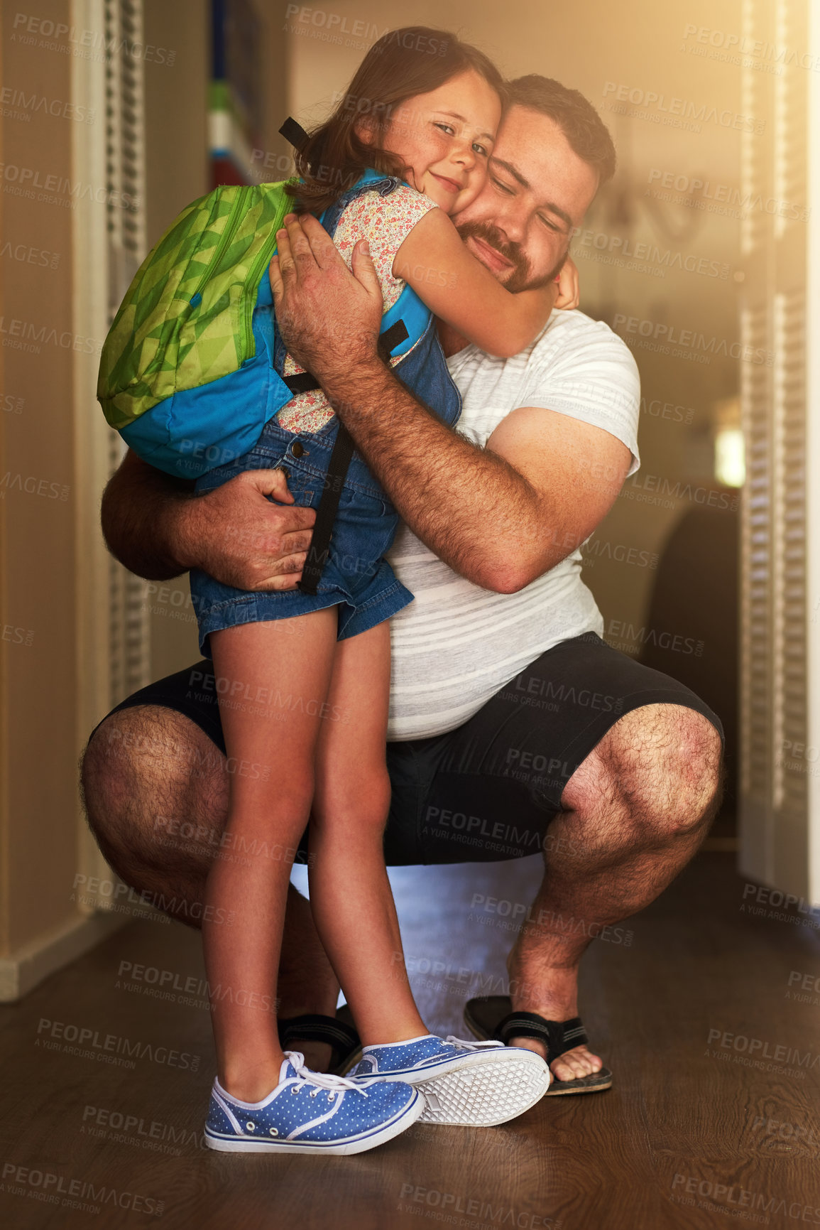 Buy stock photo Shot of an adorable little girl hugging her father after coming home from school