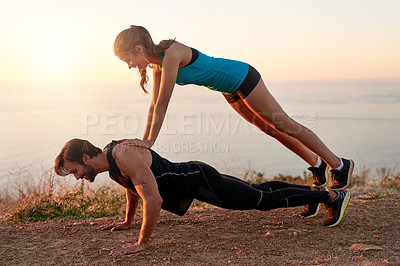 Buy stock photo Shot of a young woman lying on top of her boyfriends while he does push-ups
