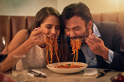 Buy stock photo Date, funny and couple eating spaghetti on a romantic dinner at a restaurant and enjoying a meal together. Lovers, man and woman playful with pasta, food or a meal on valentines day and in love
