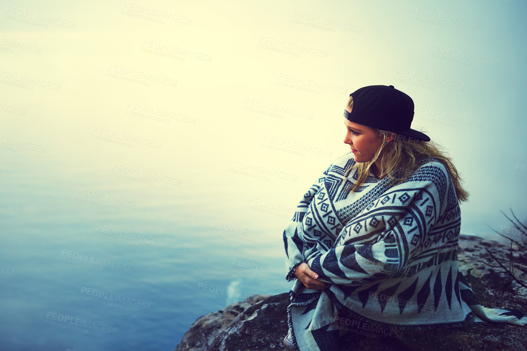 Buy stock photo Shot of a happy young woman admiring a foggy view from the top of a mountain