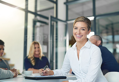 Buy stock photo Portrait of a businesswoman sitting in an office with her colleagues in the background