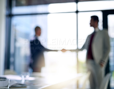 Buy stock photo Blurred shot of two businessmen shaking hands in a modern office