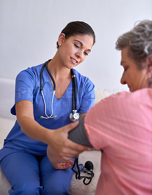 Buy stock photo Cropped shot of a nurse checking a senior patient's blood pressure