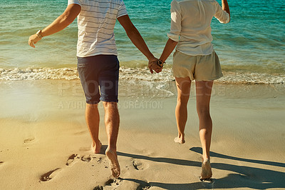 Buy stock photo Cropped shot of a carefree young couple running along the beach