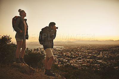 Buy stock photo Rearview shot of a couple admiring the view from a mountain top