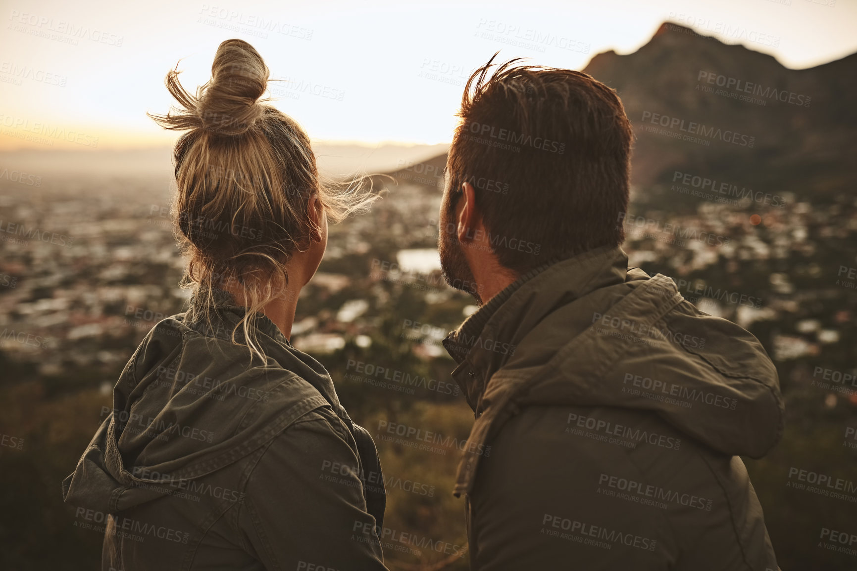 Buy stock photo Shot of a couple sitting on a mountain top