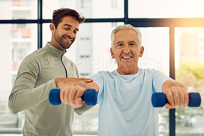 Buy stock photo Portrait of a friendly physiotherapist helping his senior patient work out with weights