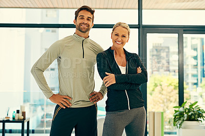 Buy stock photo Portrait of two happy physiotherapists posing together in a fitness center