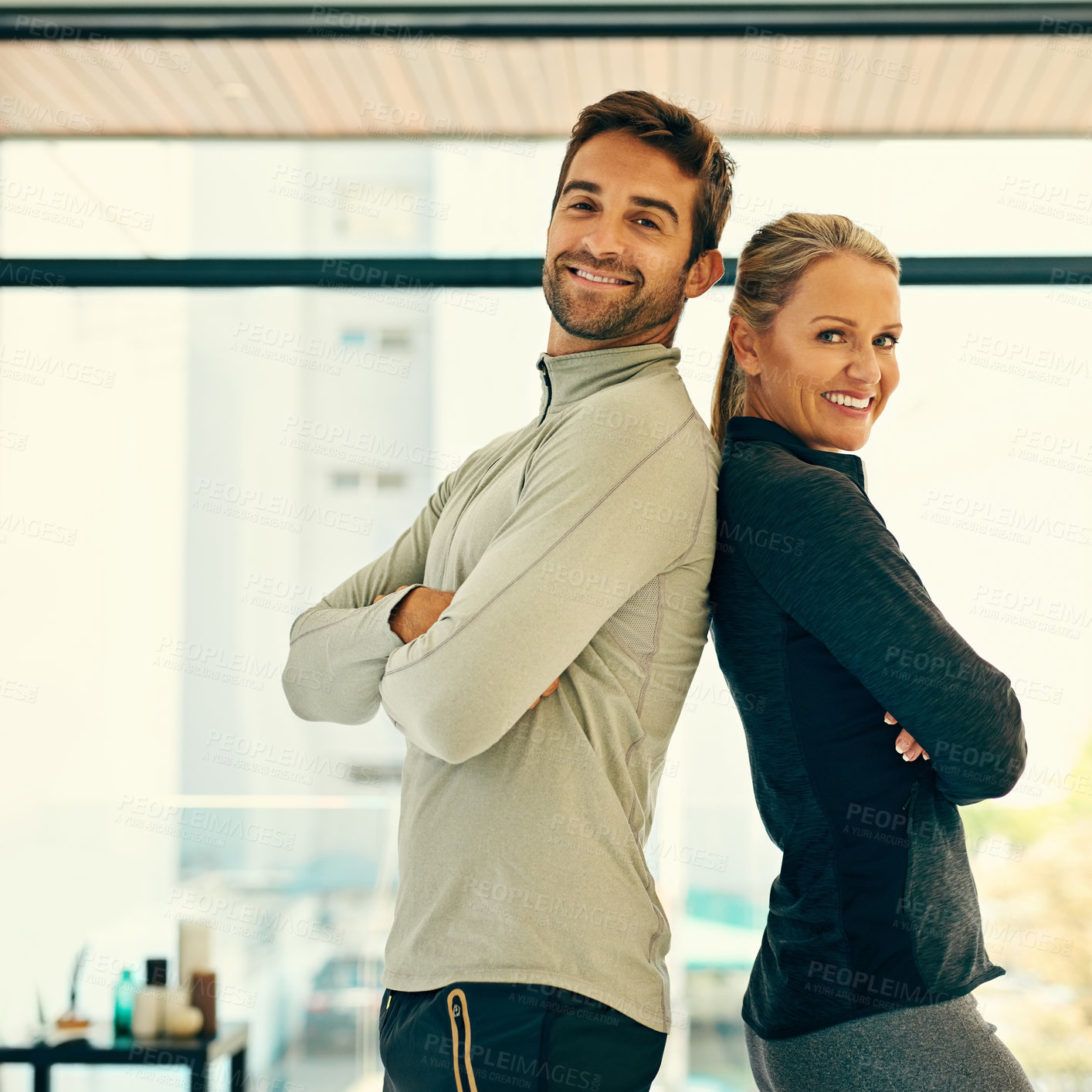Buy stock photo Portrait of two happy physiotherapists posing together in a fitness center