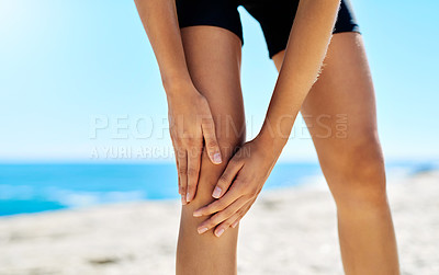 Buy stock photo Cropped shot of a woman holding on to her injured knee while out for a run