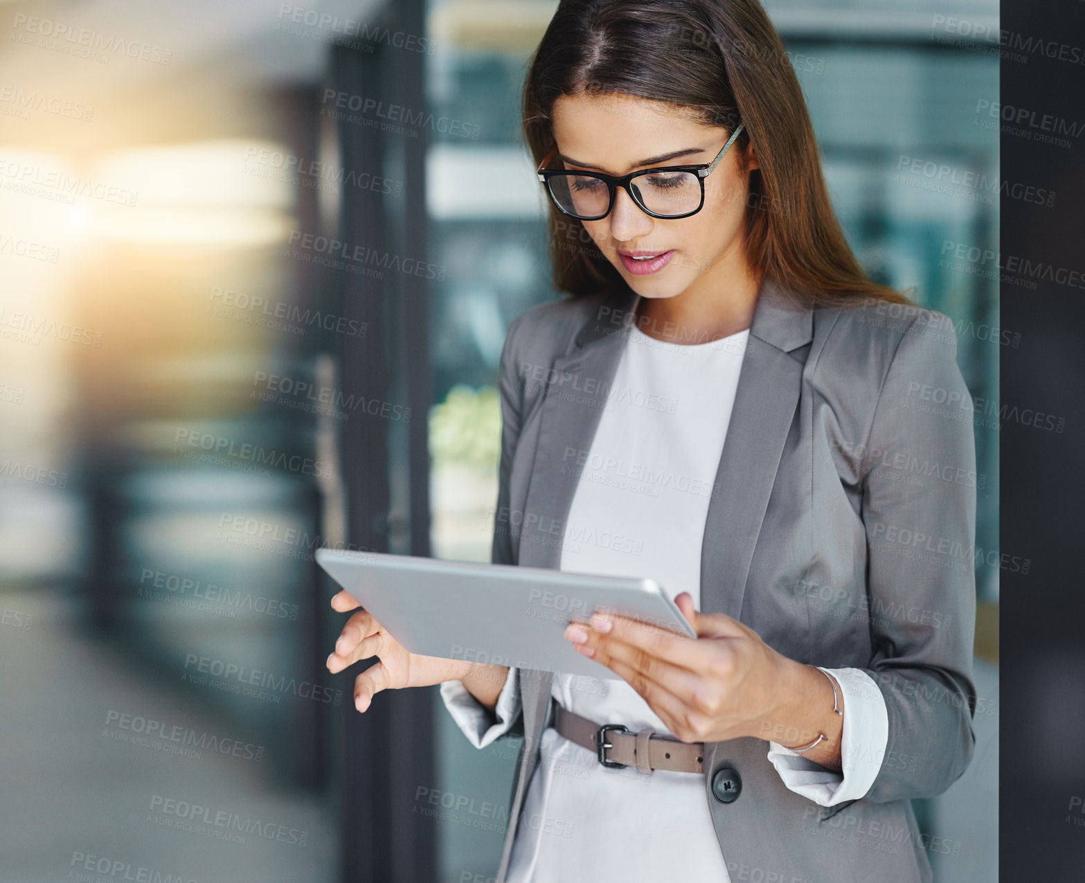 Buy stock photo Cropped shot of an attractive young businesswoman using her tablet in the office