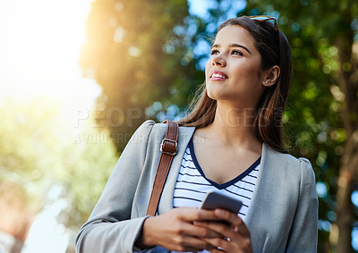 Buy stock photo Cropped shot of an attractive young woman using her cellphone while commuting to work