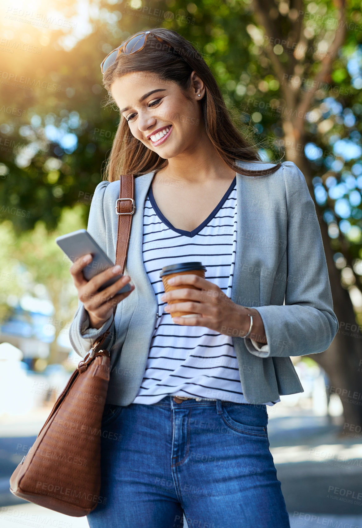 Buy stock photo Cropped shot of an attractive young woman using her cellphone while commuting to work