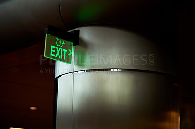 Buy stock photo Low angle shot of an exit sign against a column in a parking garage