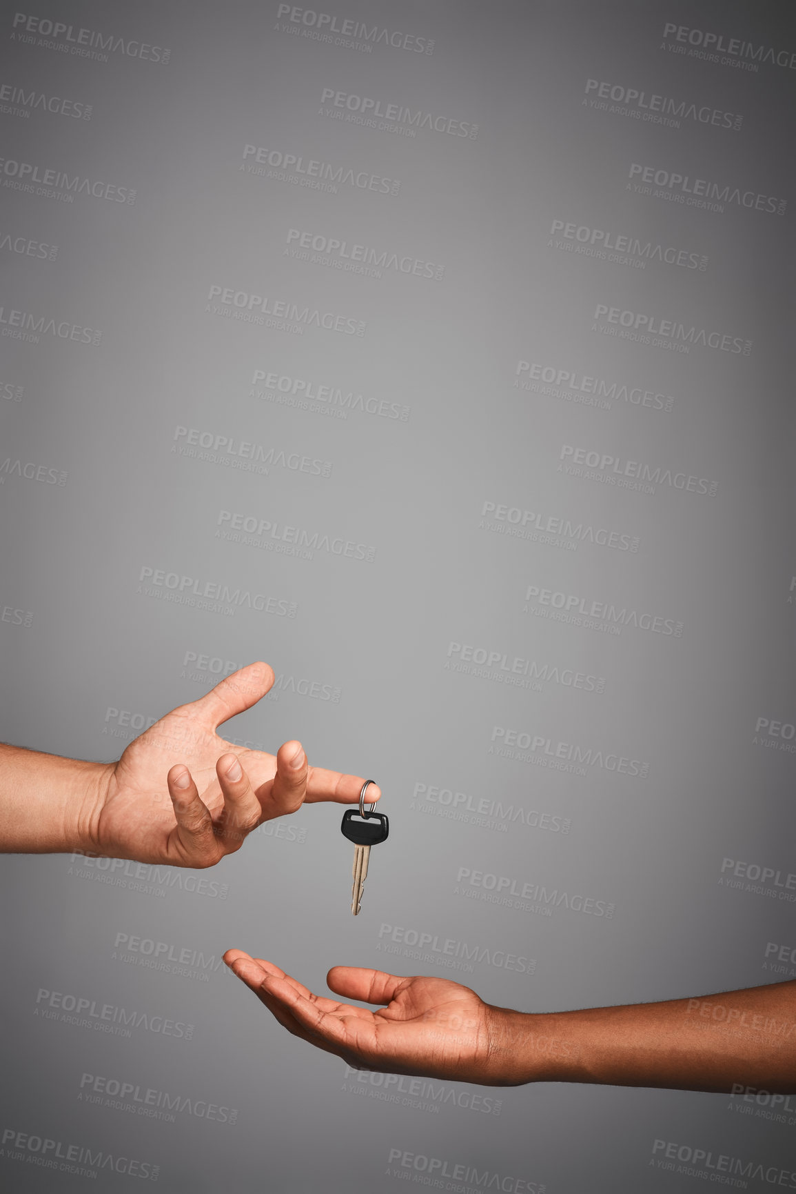 Buy stock photo Studio shot of unidentifiable hands exchanging keys against a gray background