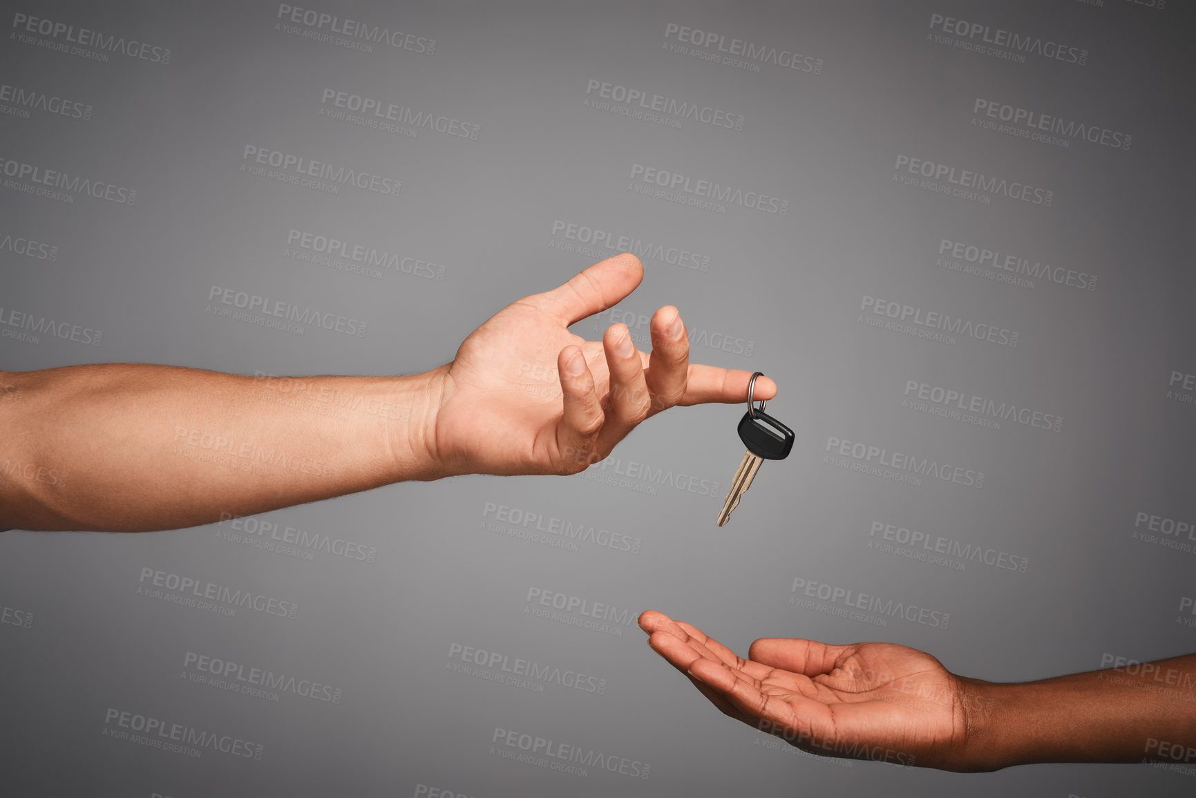 Buy stock photo Studio shot of unidentifiable hands exchanging keys against a gray background