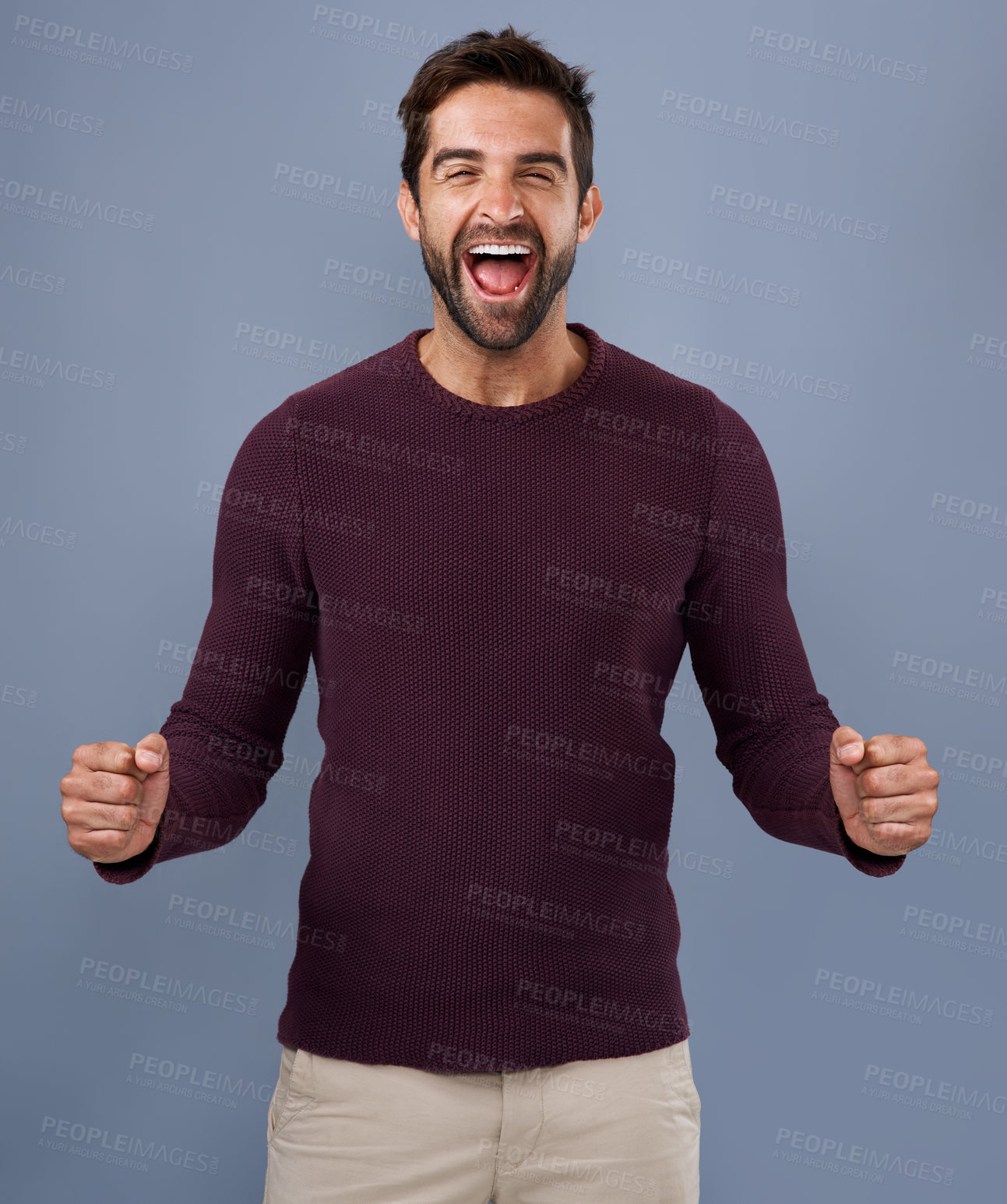 Buy stock photo Studio shot of a handsome young man cheering against a gray background