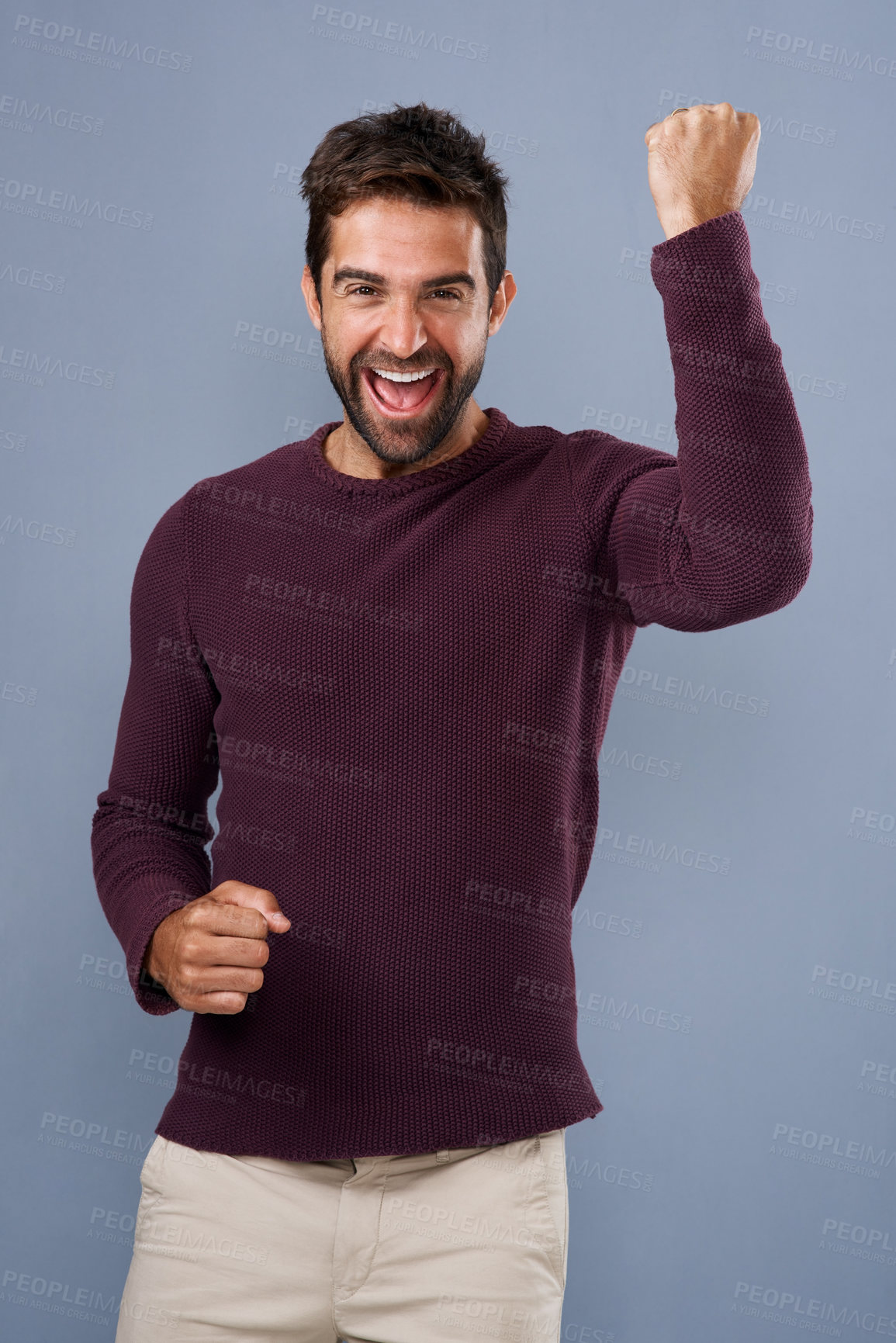 Buy stock photo Studio shot of a handsome young man cheering against a gray background