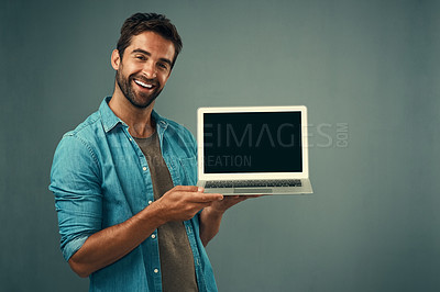 Buy stock photo Happy man, laptop and mockup screen for advertising or marketing against a grey studio background. Portrait of male person with smile showing computer display or copy space for branding advertisement