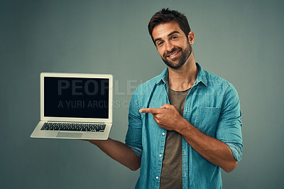 Buy stock photo Happy man, laptop and pointing to mockup screen for advertising or marketing against a grey studio background. Portrait of male person showing computer display or mock up space for advertisement