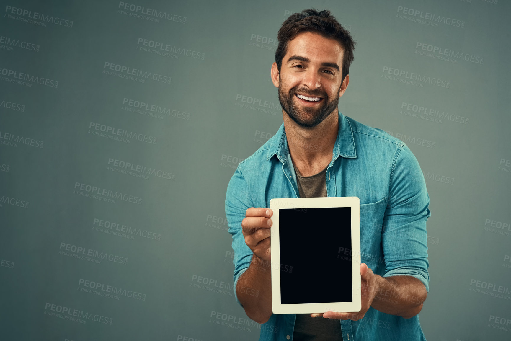 Buy stock photo Happy man, tablet and advertising screen on mockup for marketing or branding against a grey studio background. Male person with smile showing technology display or mock up space for advertisement