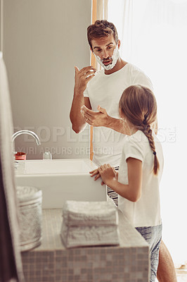 Buy stock photo Shot of a happy little girl watching her father as her shaves by the sink
