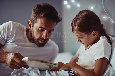 Buy stock photo Cropped shot of a father reading a bedtime story to his little girl