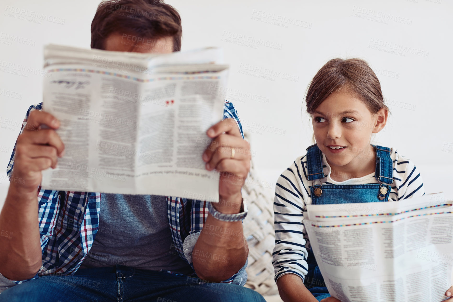 Buy stock photo Father, daughter and reading newspaper on sofa in home with smile, learning or update for global event. Man, dad and child with press, media and check for headlines, story or bonding in family house