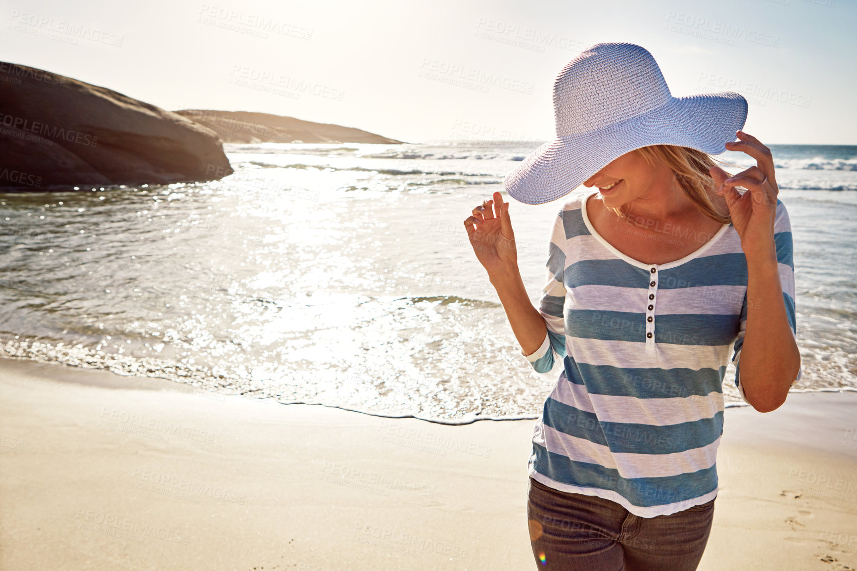 Buy stock photo Shot of an attractive mature woman enjoying a day at the beach