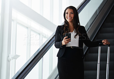 Buy stock photo Shot of a businesswoman traveling down an escalator in an airport