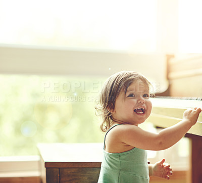 Buy stock photo Cropped shot of an adorable little girl playing on the piano at home