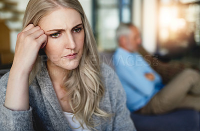 Buy stock photo Cropped shot of a woman looking despondent after having a fight with her husband at home