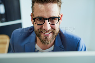 Buy stock photo Portrait of a young businessman working on a computer in an office
