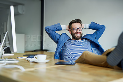 Buy stock photo Shot of a young businessman taking a break with his feet up on the desk in an office
