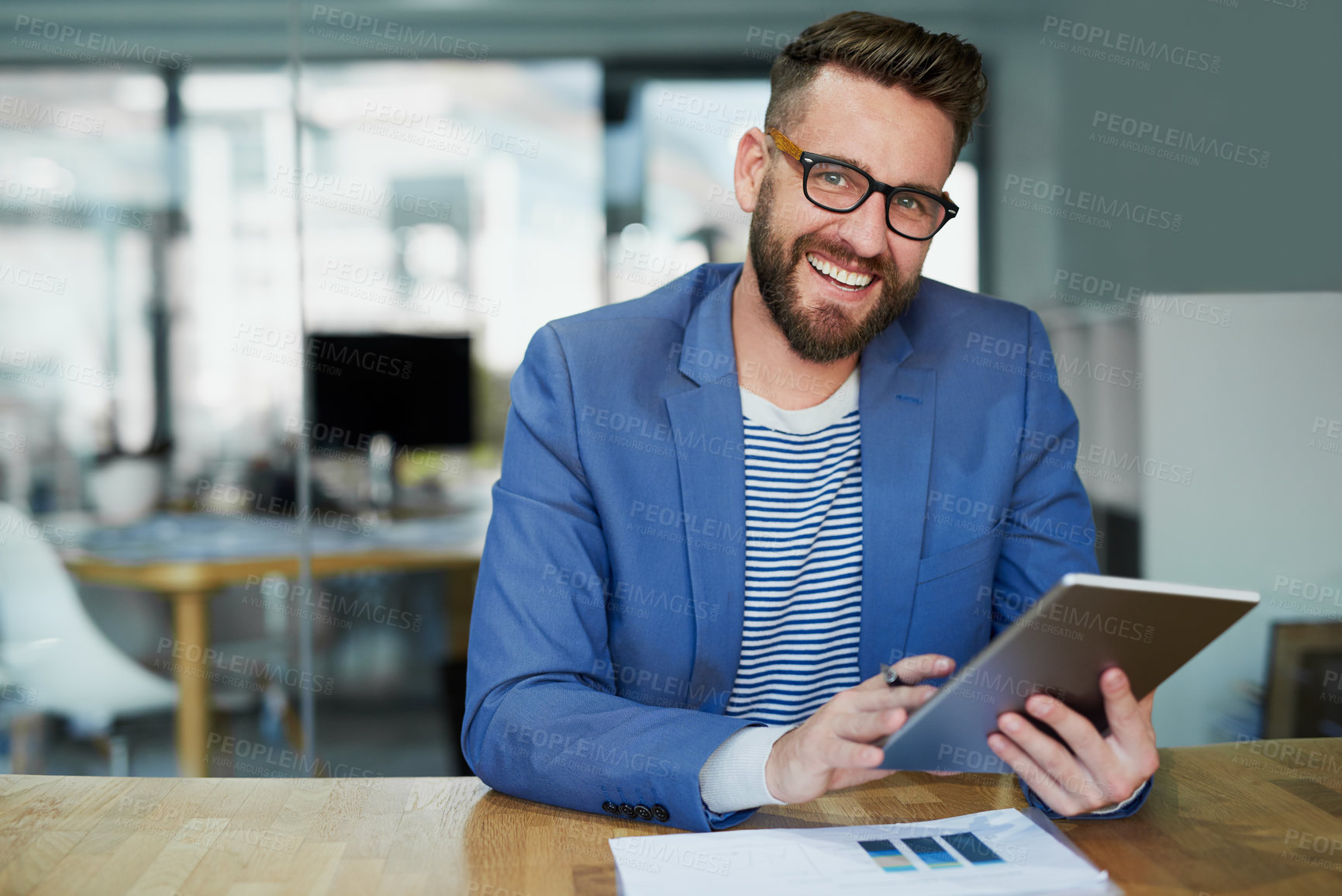 Buy stock photo Portrait of a young businessman working on a digital tablet in an office