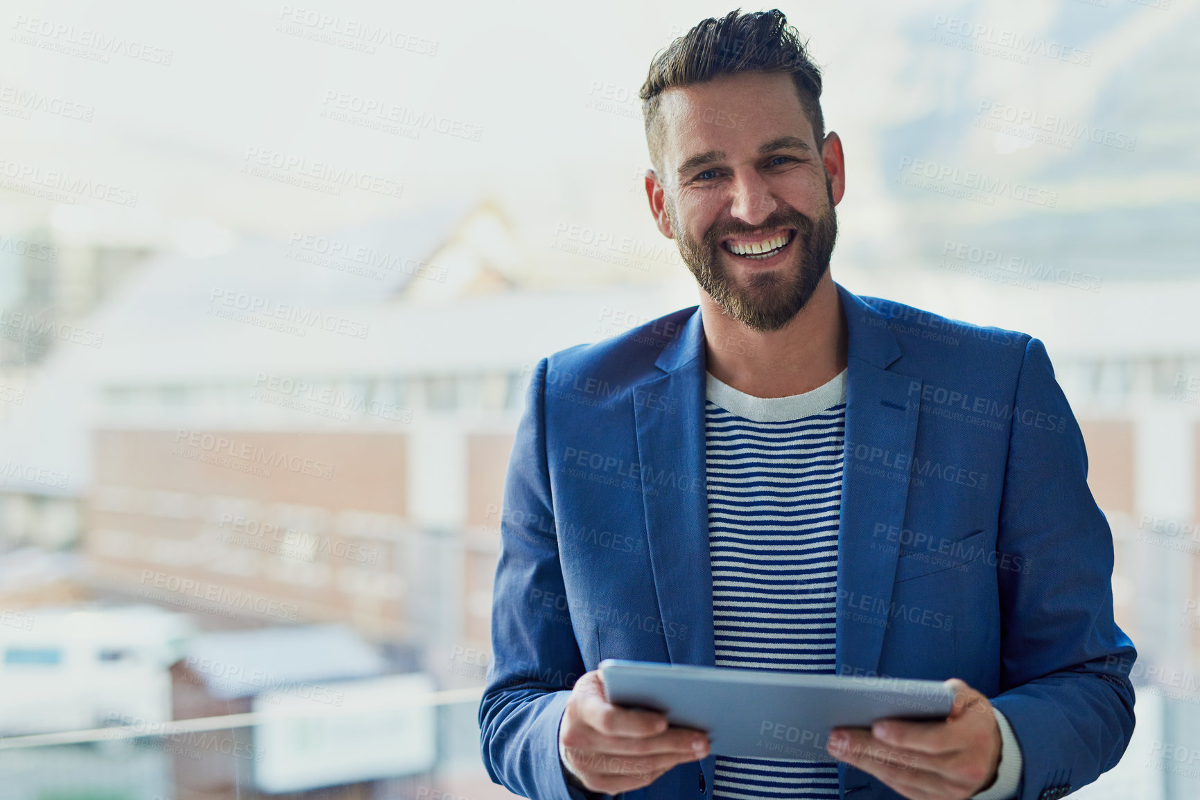 Buy stock photo Portrait of a young businessman working on a digital tablet in an office