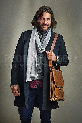 Buy stock photo Portrait of a stylishly dressed man posing with a leather satchel in the studio