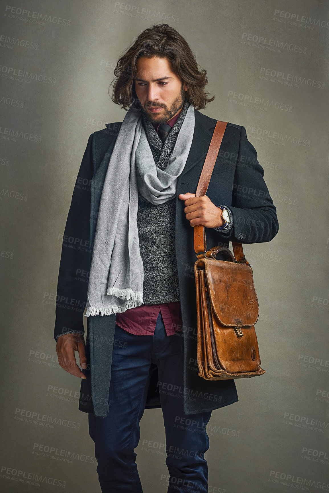 Buy stock photo Shot of a stylishly dressed man posing with a leather satchel in the studio