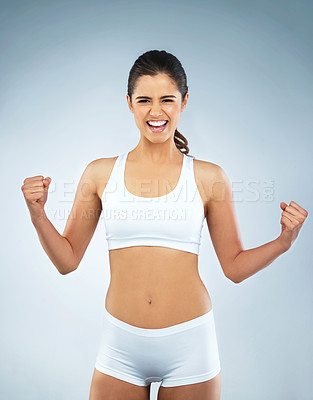 Buy stock photo Studio portrait of an attractive young woman cheering against a grey background