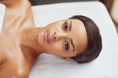 Buy stock photo Portrait of an attractive young woman relaxing on a massage table at a beauty spa