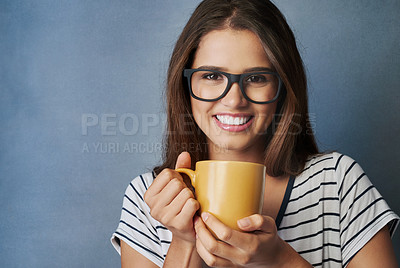 Buy stock photo Studio shot of an attractive young woman holding a coffee mug against a gray background
