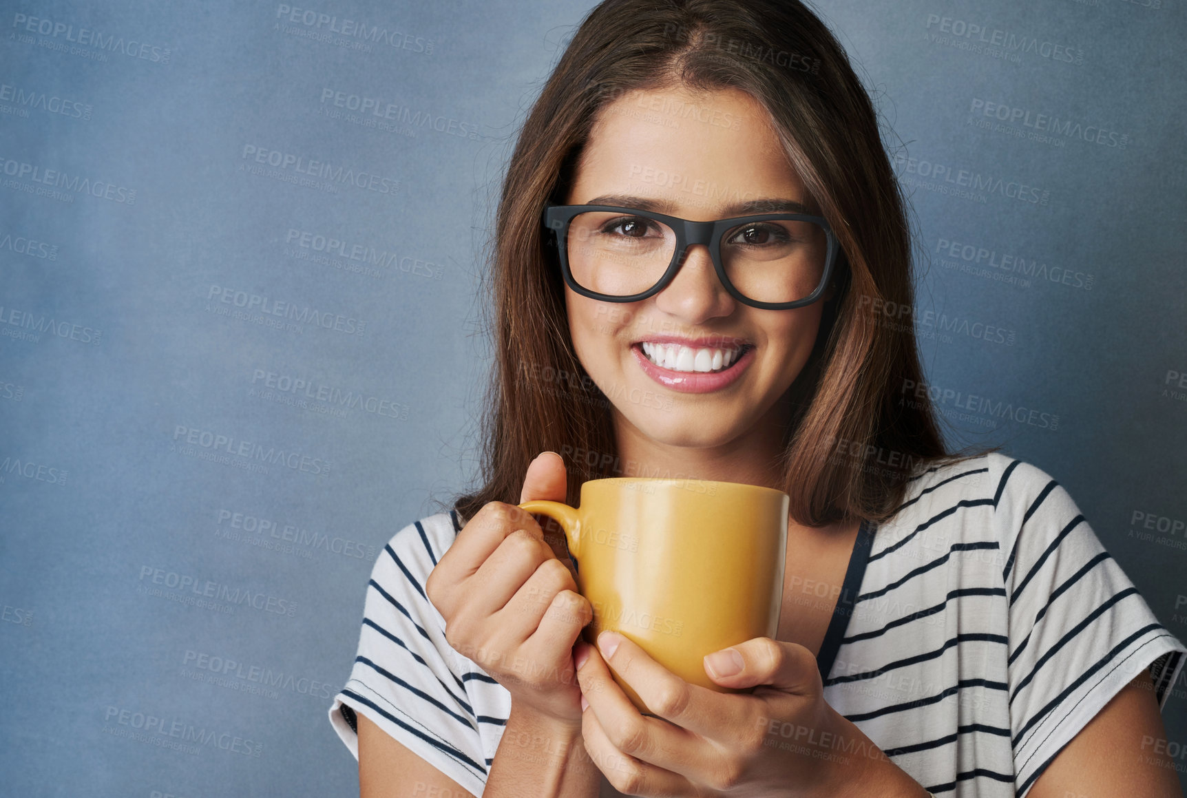 Buy stock photo Woman, student and coffee in studio with portrait, drink and glasses on blue background. Smile, caffeine and hot chocolate for female person, hands and matcha latte or green tea for relax or break